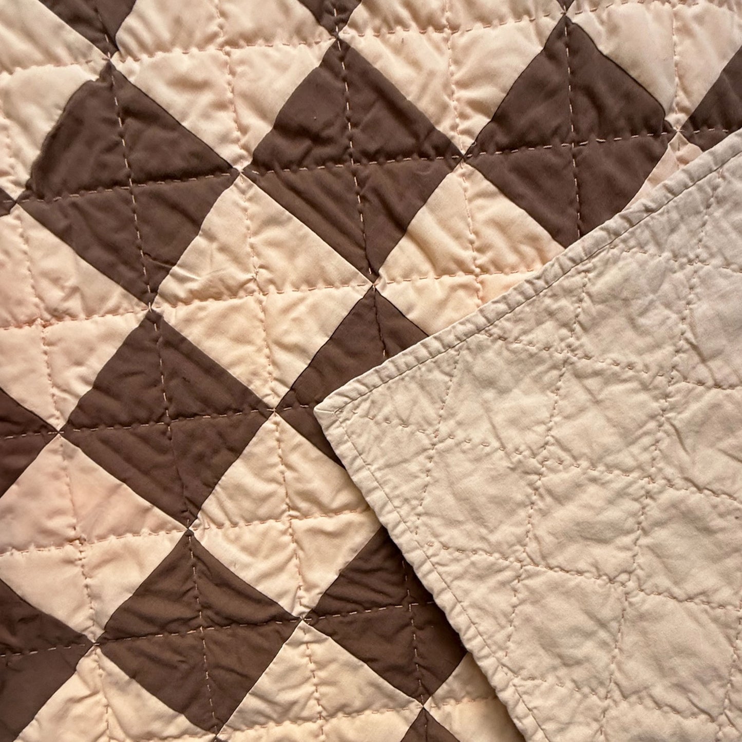Close-up of hand quilting stitches and cream backing on Deadwood Dick Twin heirloom quilt.