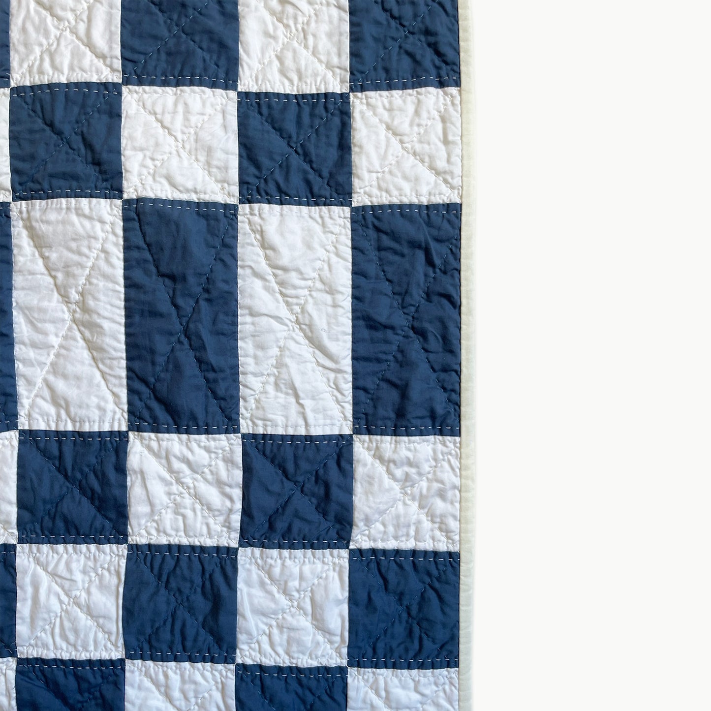 Close-up of the checkerboard pattern in the Hasso Garden quilt, showcasing Sashiko-style hand and machine quilting.