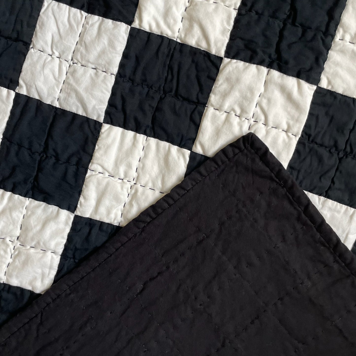 Back of ‘Hollywood Baby’ quilt by Los Angeles Floral Company, with solid black backing and detailed hand-quilting.
