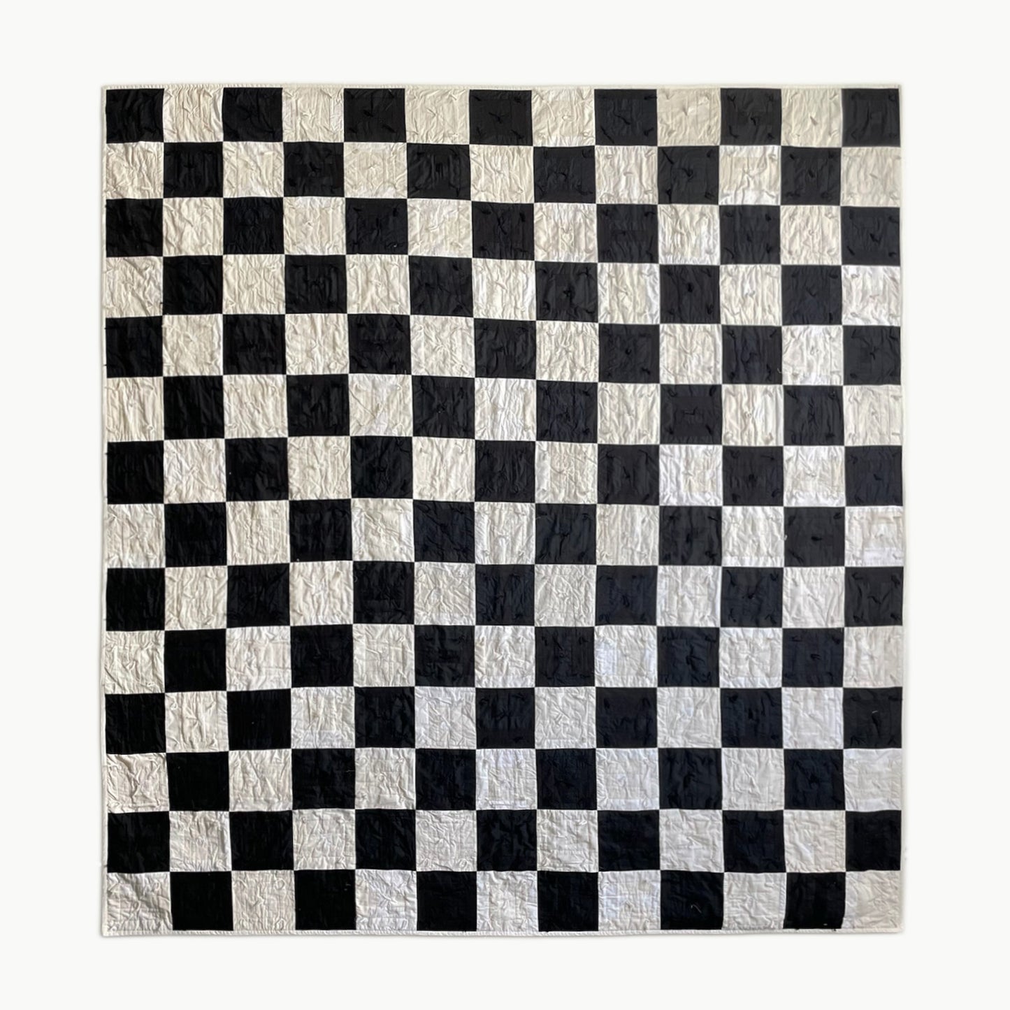 Hand-tied ‘Old Hollywood’ twin-size quilt by Los Angeles Floral Company, showcasing a bold black-and-white checkerboard pattern inspired by classic films.
