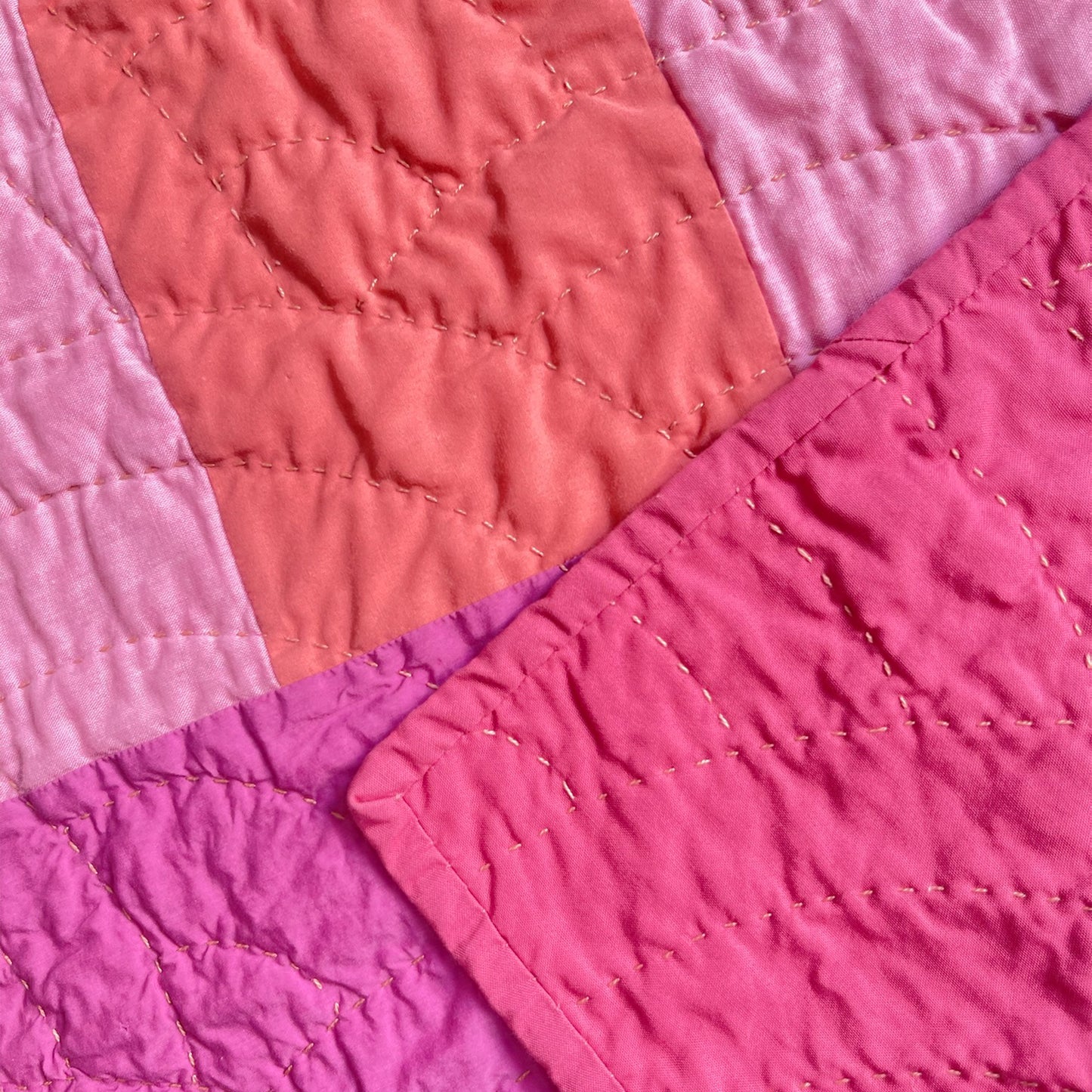 Back of 'Pokeberry' quilt by Los Angeles Floral Company, featuring soft pink backing and detailed hand-stitching.