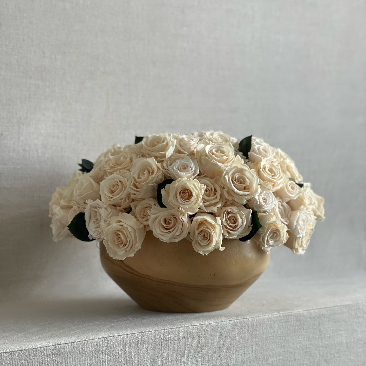 Teakwood Ivory arrangement showcasing hand-selected preserved roses in a minimalist wooden vessel.