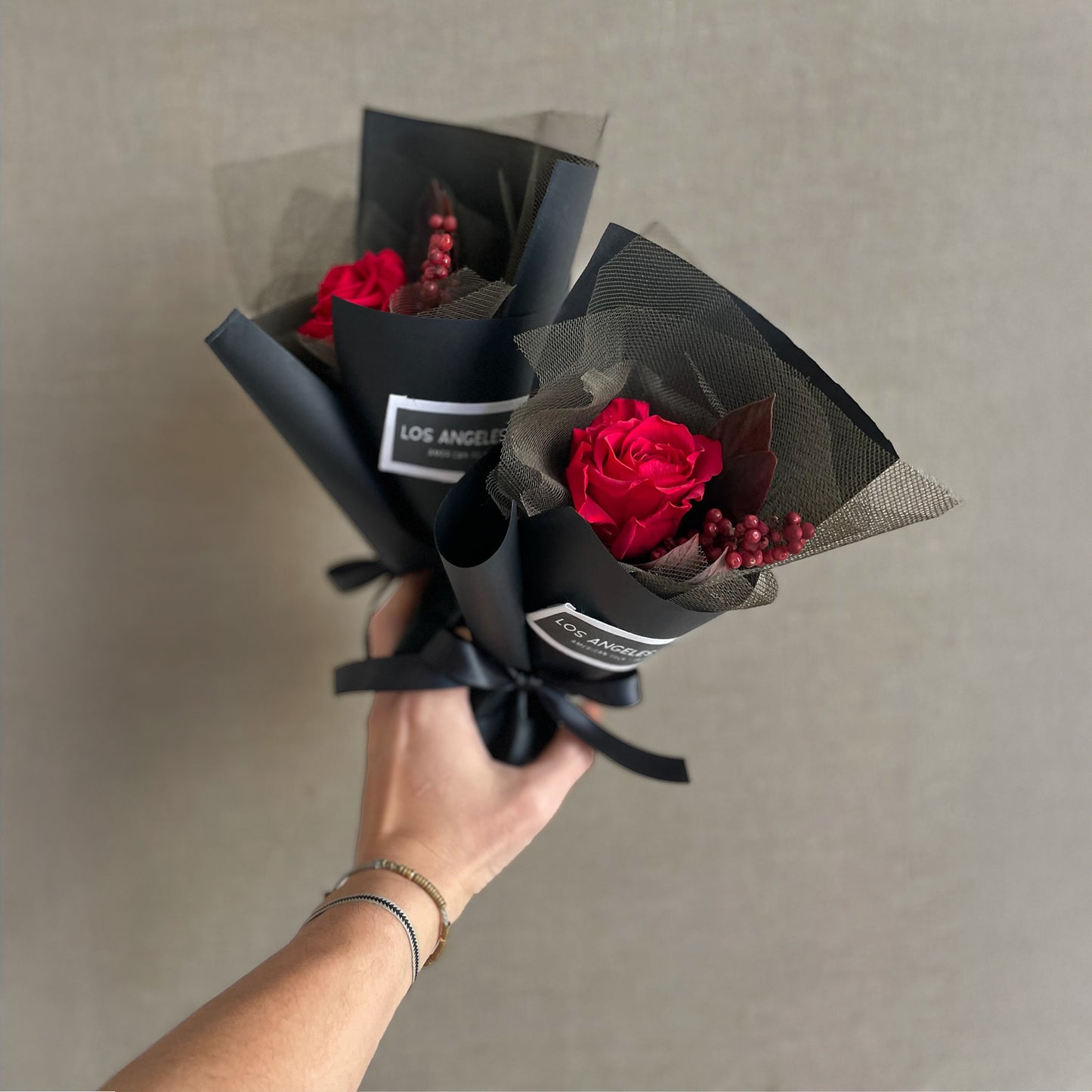 Mini bouquet with a preserved red rose, California pepperberry, and red velvet leaves in a secure presentation wrap, perfect for Valentine’s Day gifting.
