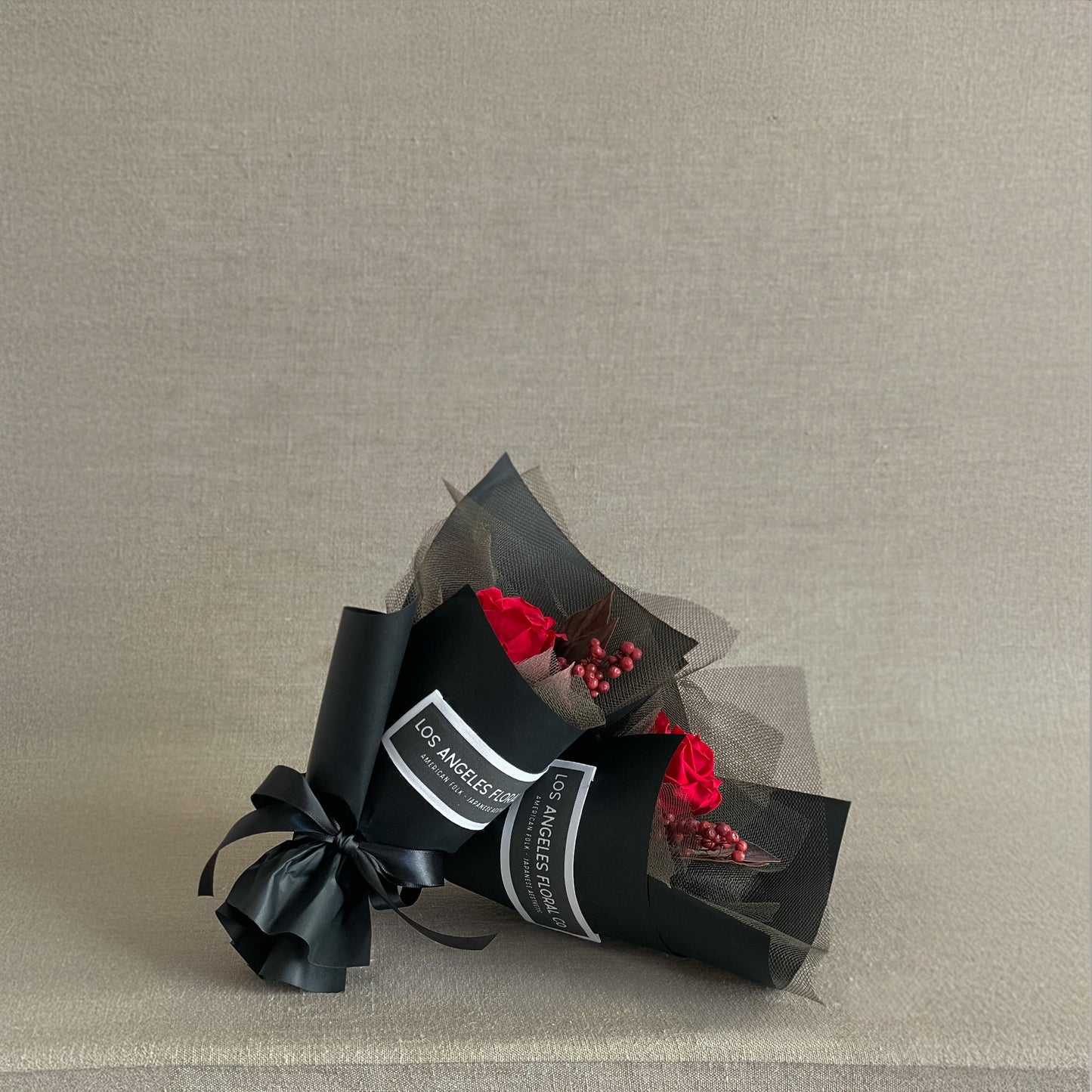 Mini bouquet with a preserved red rose, California pepperberry, and red velvet leaves in a secure presentation wrap, perfect for Valentine’s Day gifting.