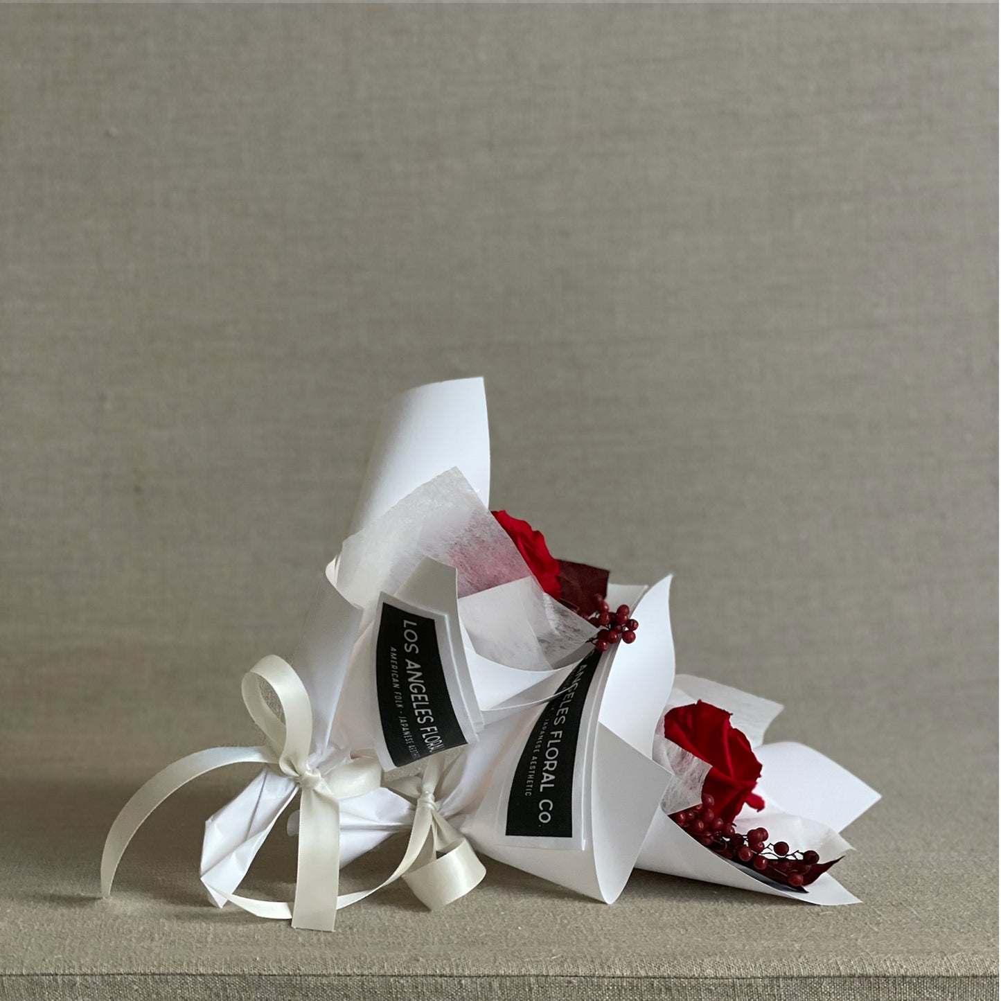 A trendy red rose mini bouquet in white wrap, perfect for Valentine’s Day gifts or pairings.