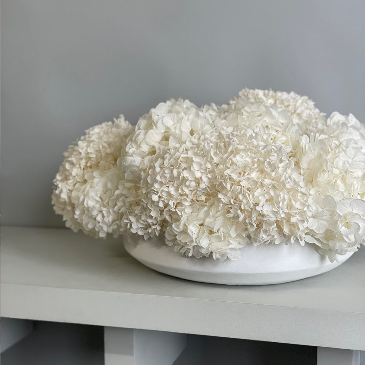 Top angle of White Hydrangea Serene arrangement with preserved hydrangeas in ivory tones.