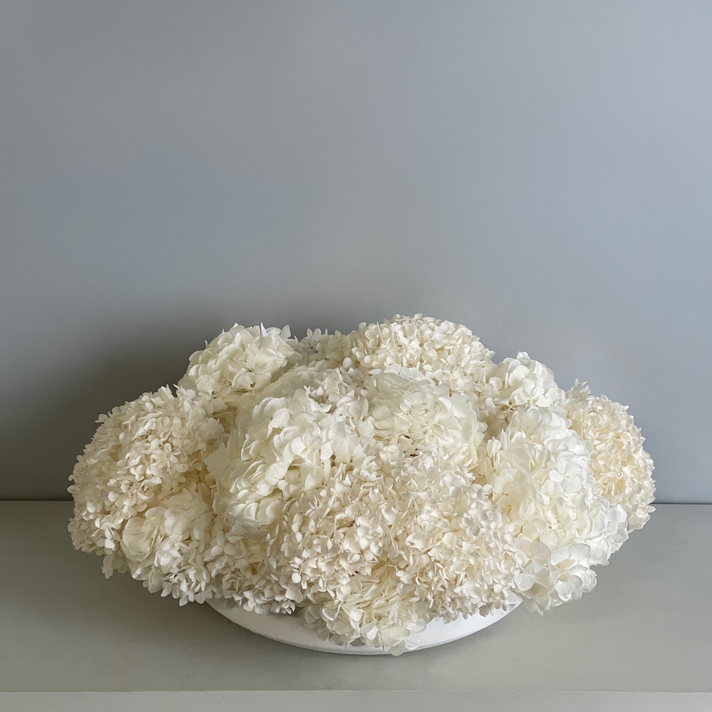 Top angle of White Hydrangea Serene arrangement with preserved hydrangeas in ivory tones.