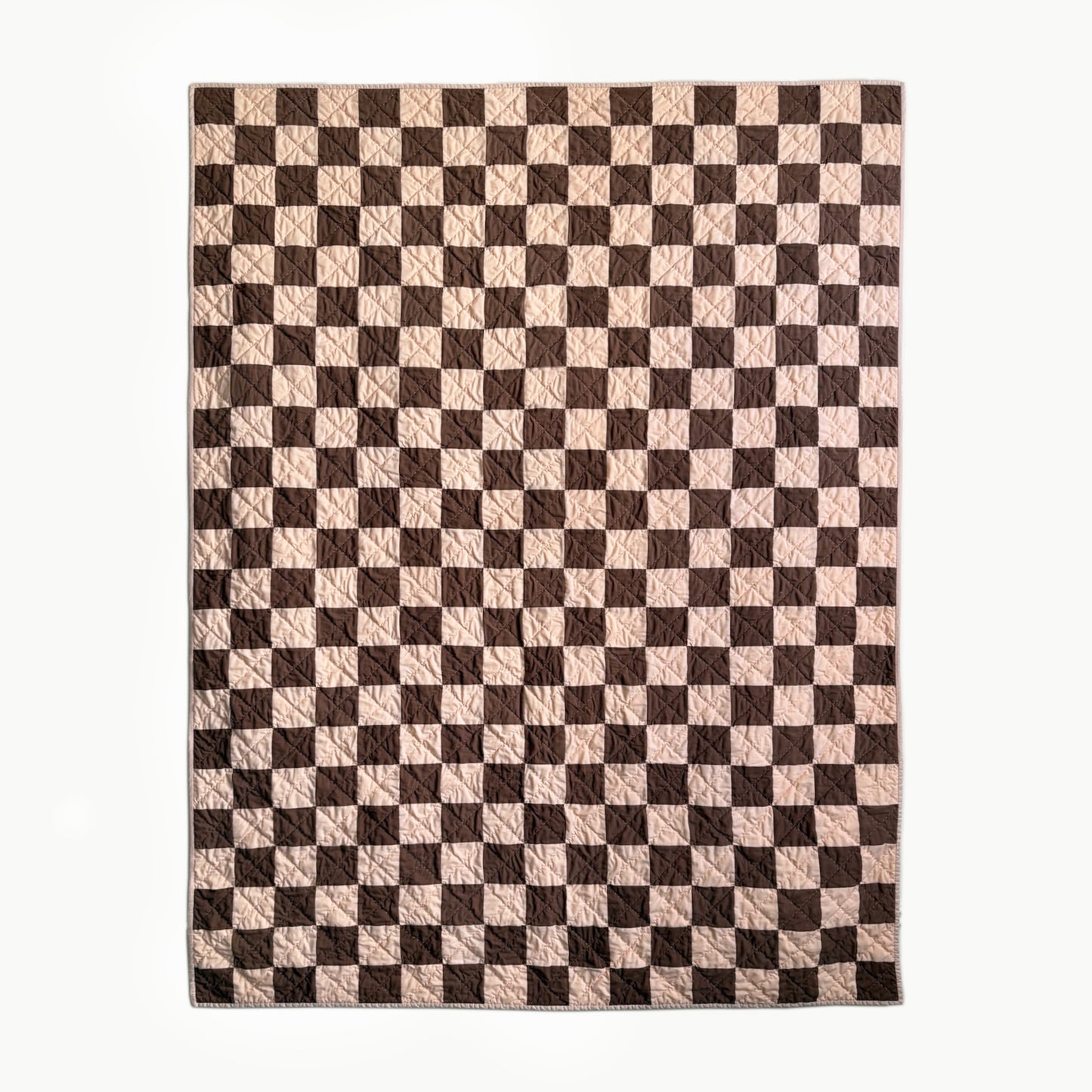 Full view of peach and brown checkerboard hand-quilted Twin quilt inspired by Nat Love’s Deadwood victory.