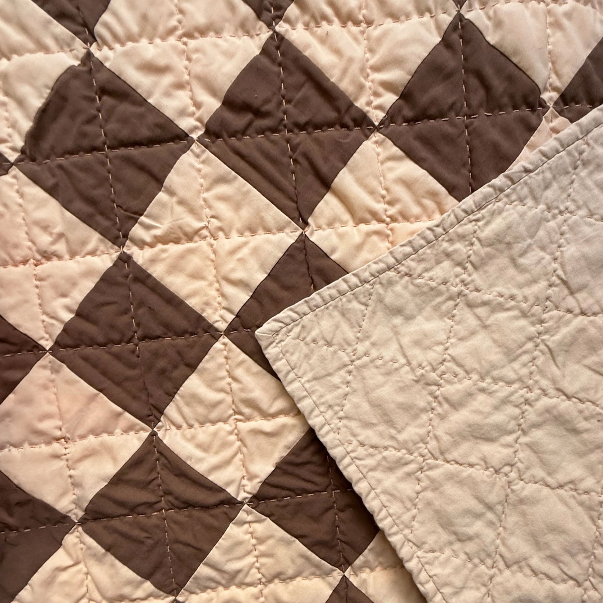 Close-up of hand quilting stitches and cream backing on Deadwood Dick Twin heirloom quilt.