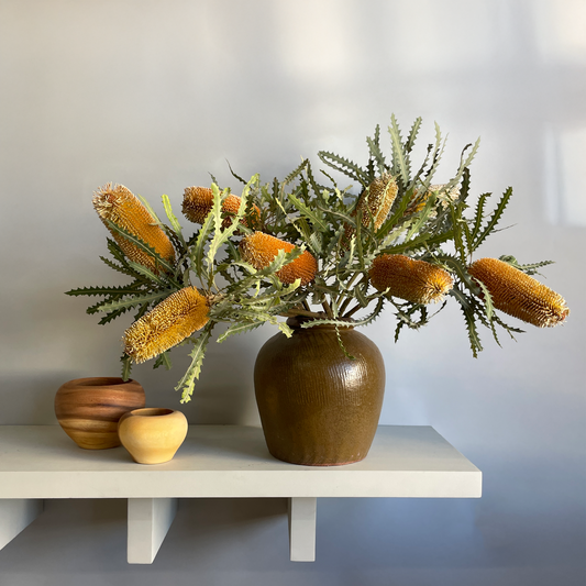 A full view of the Fresh Banksia Ginger Jar displayed in a modern setting, emphasizing its dramatic foliage and natural beauty.