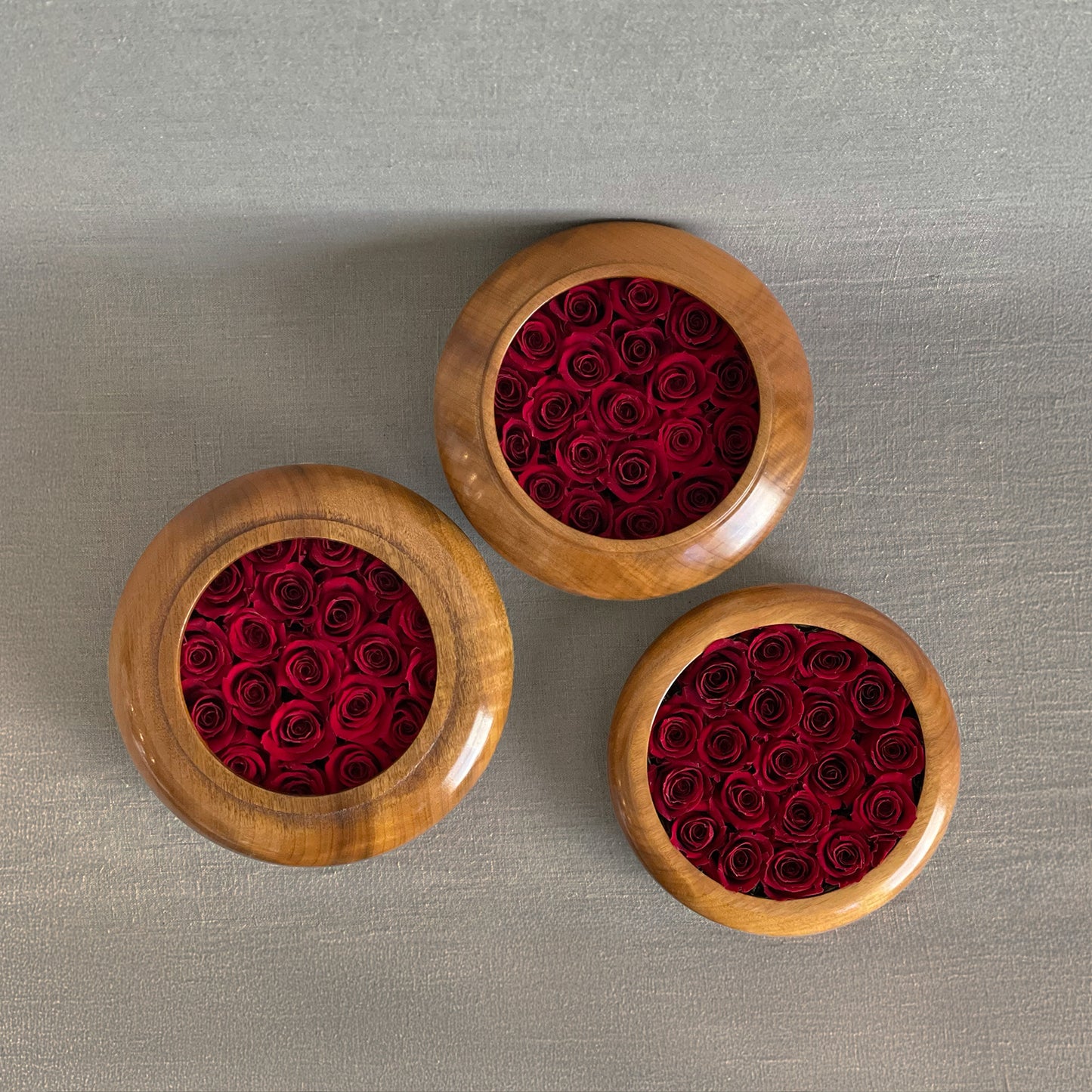 Handcrafted wooden bowls filled with preserved red roses from the Hearts Honed Collection