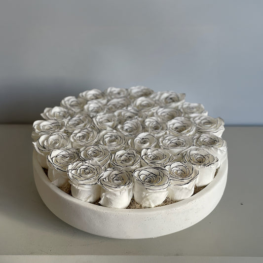 Preserved ivory roses with hand-drawn black line details, displayed in a minimalist ceramic bowl, evoking Art Deco style.