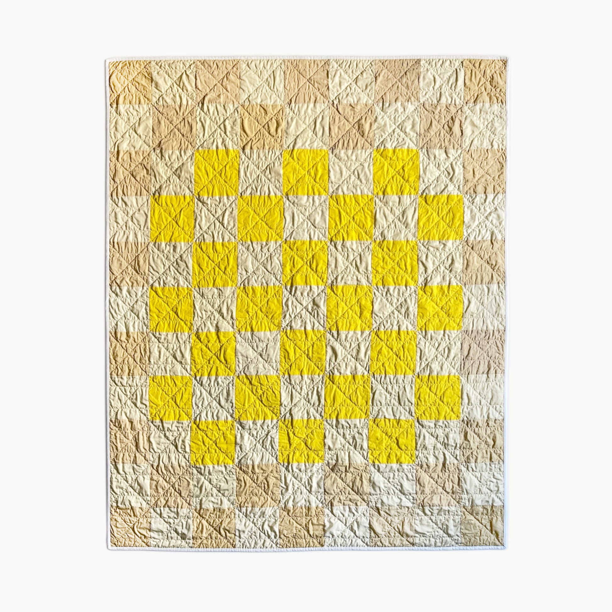 Hand-stitched ‘Desert Dune’ throw-size quilt by Los Angeles Floral Company, featuring bright yellow squares and soft neutral tones inspired by California’s desert.