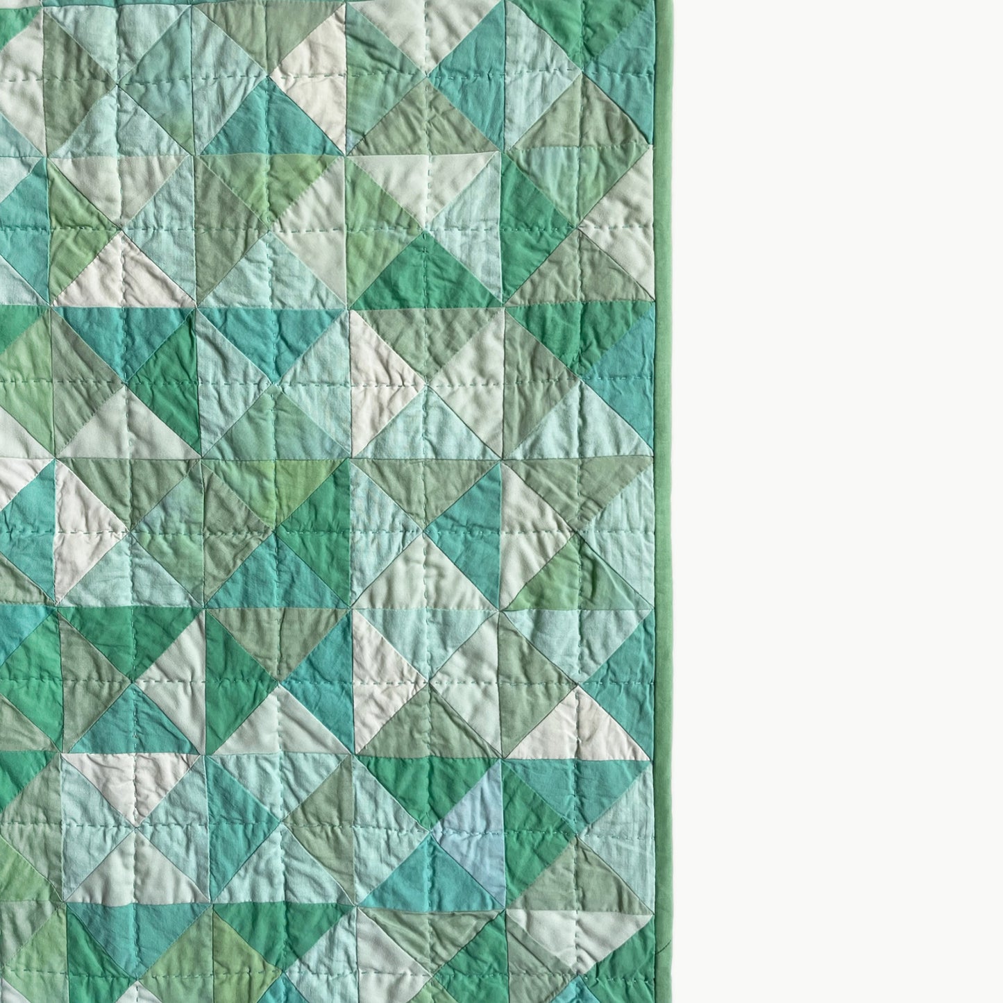 Close-up of the soft green geometric pattern on the ‘Hisui [Jade]’ quilt by Los Angeles Floral Company, showcasing Sashiko-style hand-stitching.