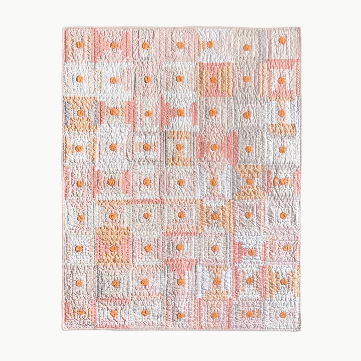 Hand-stitched quilt by Los Angeles Floral Company in soft shades of pale beige, peach, and plum with orange circle accents, inspired by umeboshi plums.