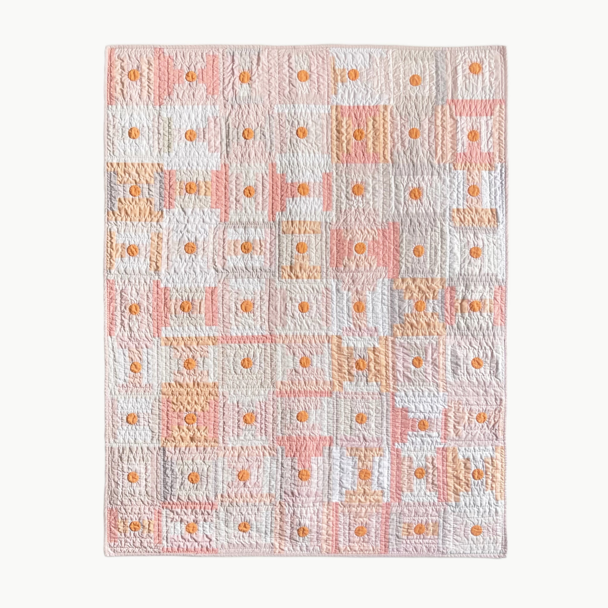 Hand-stitched quilt by Los Angeles Floral Company in soft shades of pale beige, peach, and plum with orange circle accents, inspired by umeboshi plums.