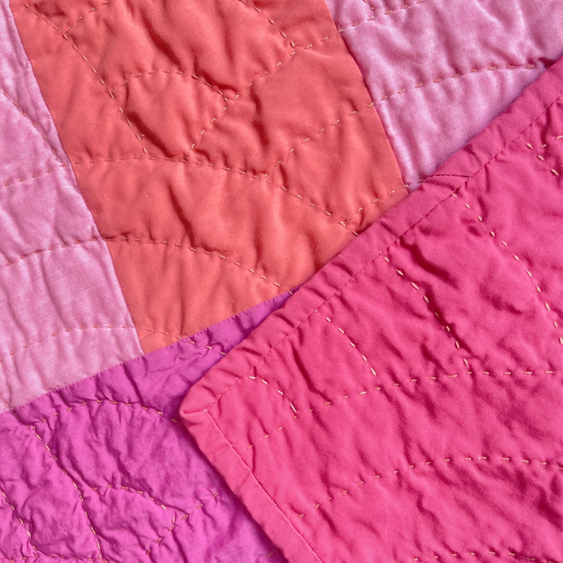 Back of 'Pokeberry' quilt by Los Angeles Floral Company, featuring soft pink backing and detailed hand-stitching.