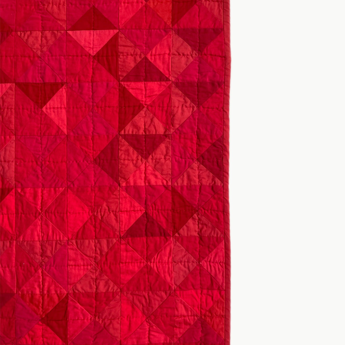 Close-up of the sharp geometric design in R.A.E.’s quilt, showcasing cotton hand-stitching.