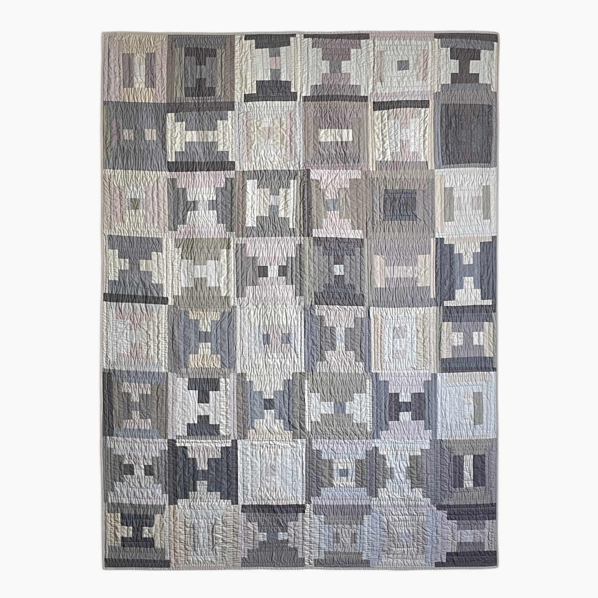 Hand-stitched twin-size ‘Stone Steps’ quilt by Los Angeles Floral Company, featuring grey hues and Courthouse Steps pattern.