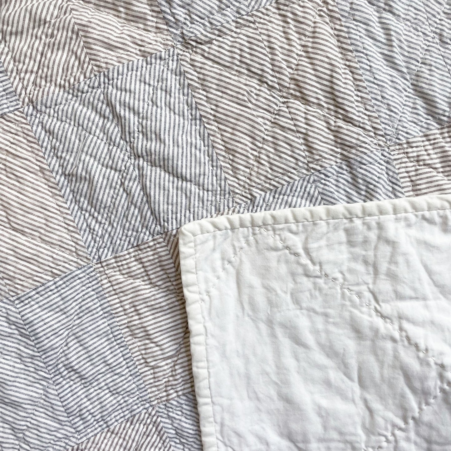 Back of the ‘Stripe Study 2’ quilt by Los Angeles Floral Company, highlighting solid fabric and detailed hand-stitching.