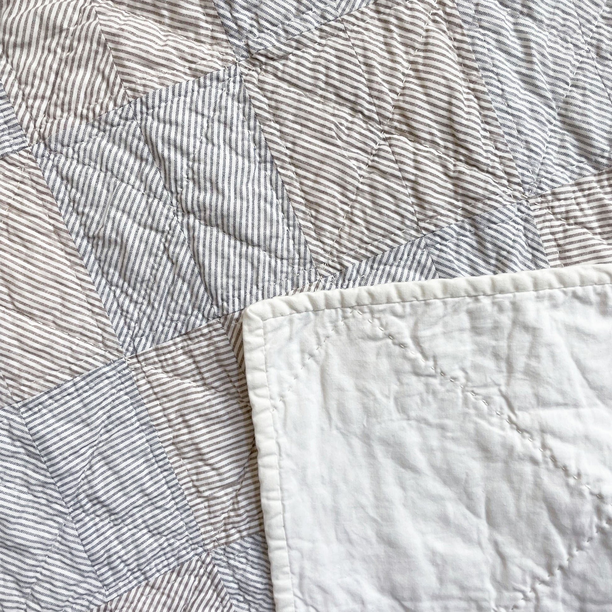 Back of the ‘Stripe Study 2’ quilt by Los Angeles Floral Company, highlighting solid fabric and detailed hand-stitching.
