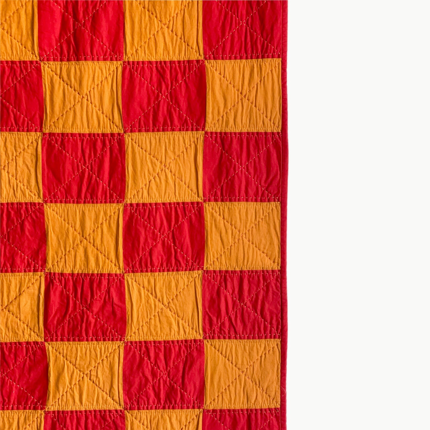 Close-up of the checkerboard pattern in the ‘Tokyo Sunset’ quilt by Los Angeles Floral Company, showcasing Sashiko-style hand and machine quilting.