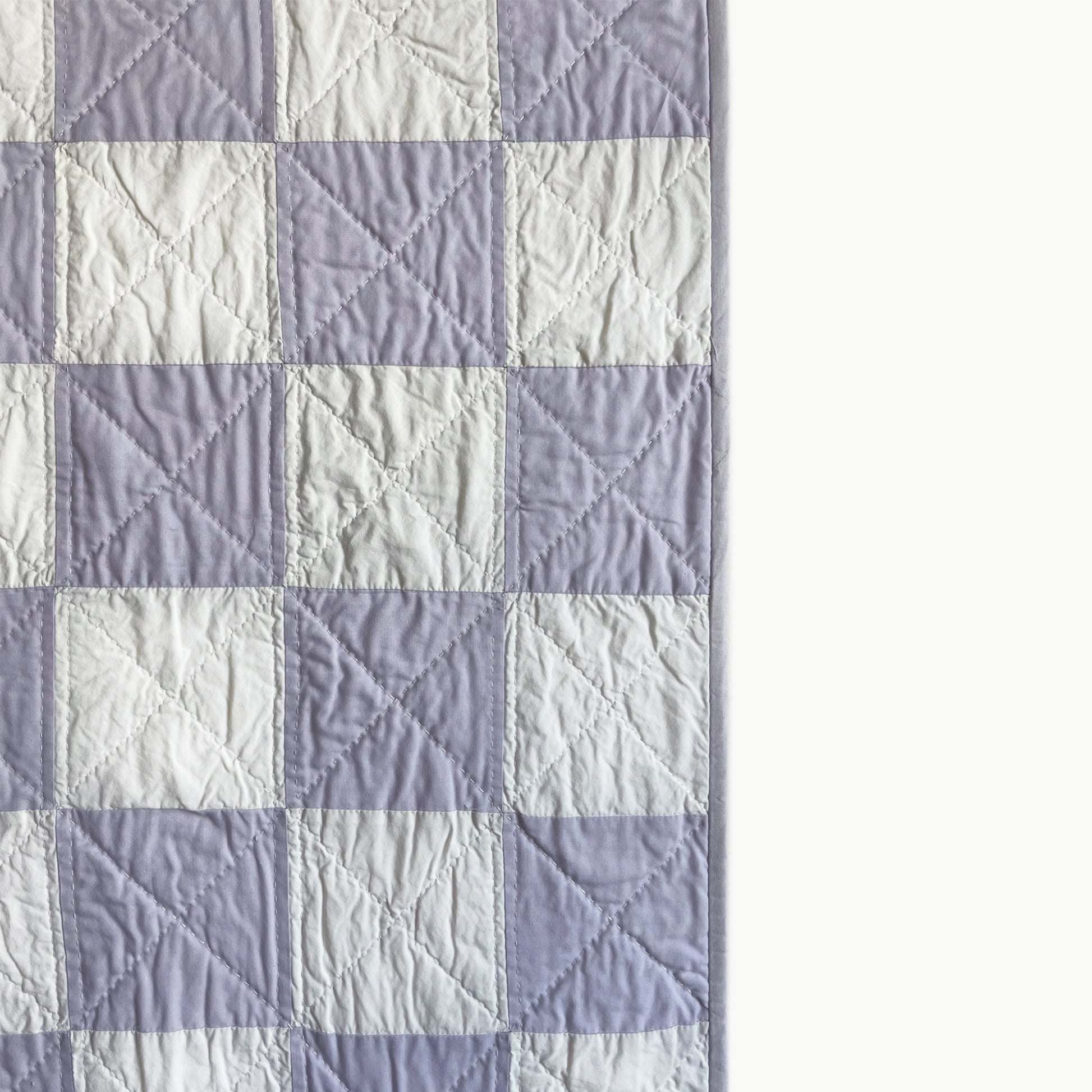 Close-up of the checkerboard pattern in the 'Waft & Wisp' quilt by Los Angeles Floral Company, showcasing the Sashiko-style hand and machine quilting.