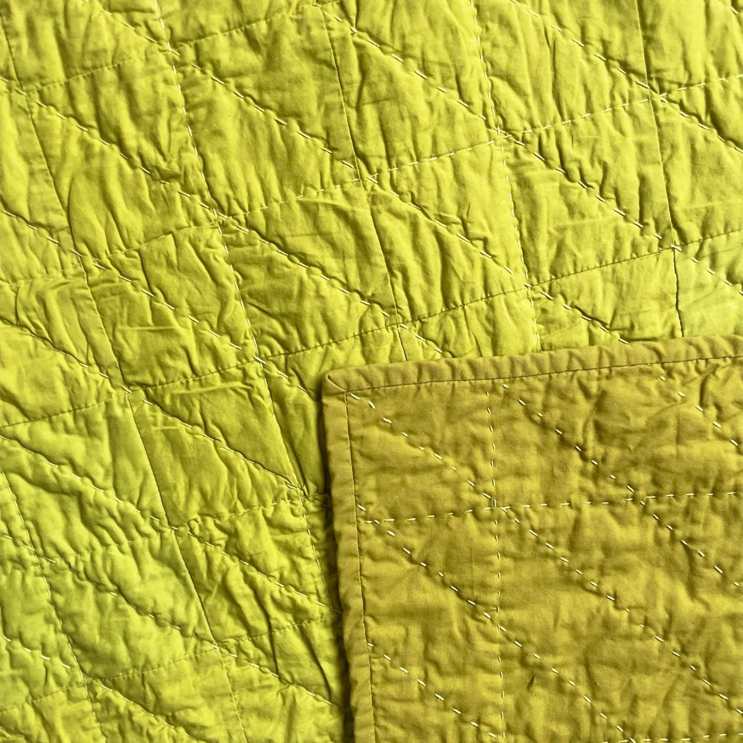Back of the Wakakusa quilt, with solid backing and detailed hand-stitching.