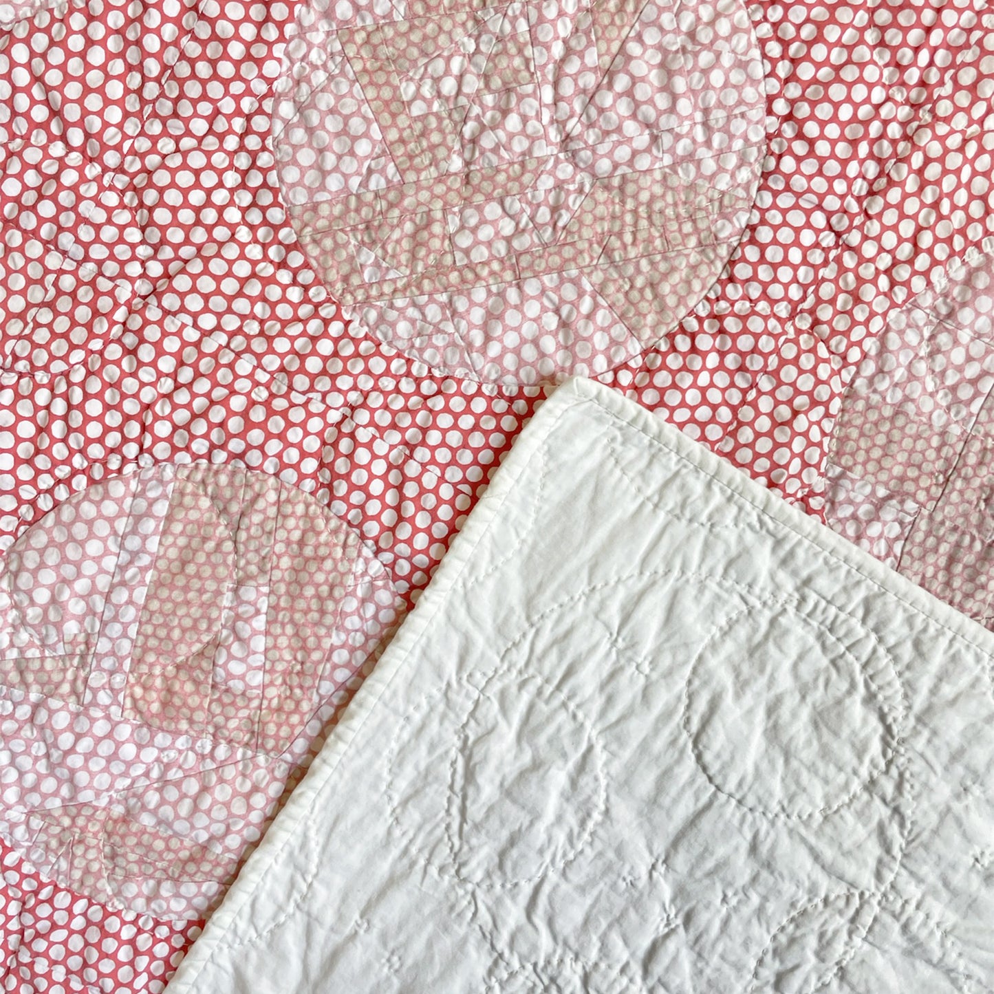 Back of ‘Yayoi’s Red Dot’ quilt by Los Angeles Floral Company, with solid white backing and detailed hand-stitching.