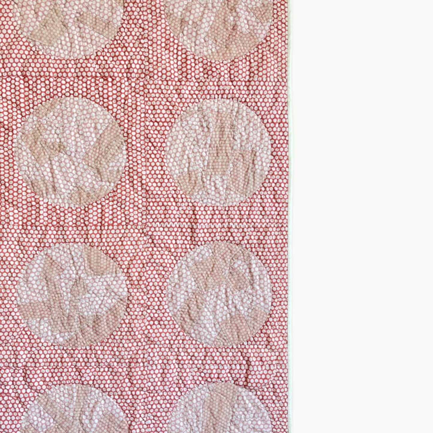 Close-up of the reverse appliqué circles in the ‘Yayoi’s Red Dot’ quilt by Los Angeles Floral Company, showcasing Sashiko-style hand-stitching.