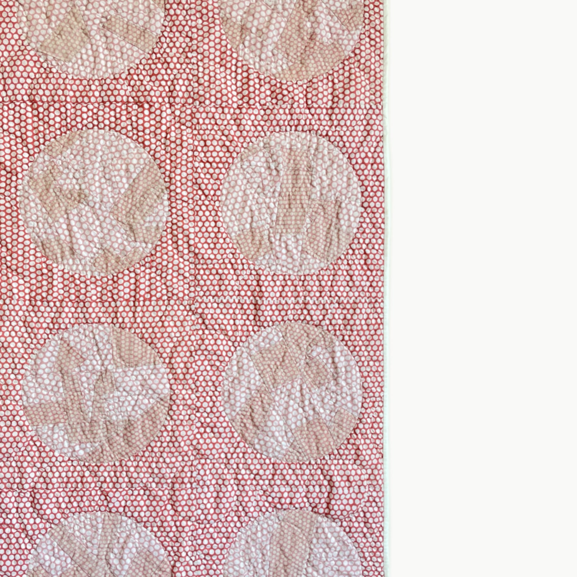 Close-up of the reverse appliqué circles in the ‘Yayoi’s Red Dot’ quilt by Los Angeles Floral Company, showcasing Sashiko-style hand-stitching.