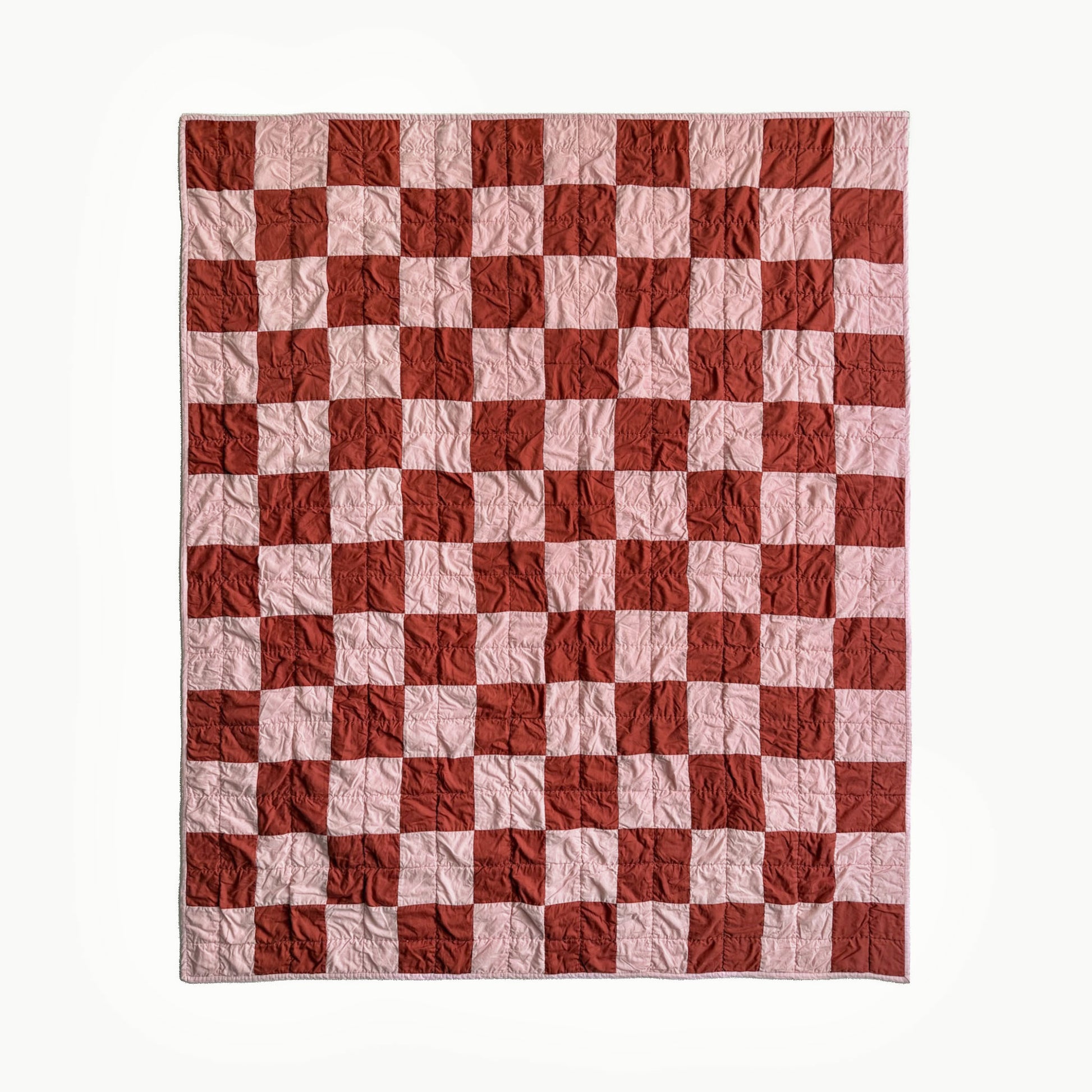 Full view of pink and rust checkerboard hand-quilted throw quilt inspired by Nat Love, Showman Series Act One.