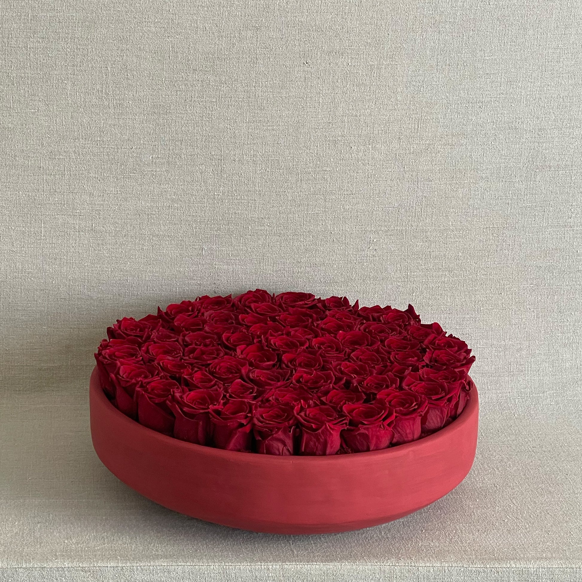 Red Rose Serene arrangement featuring preserved red roses in a modern red ceramic bowl