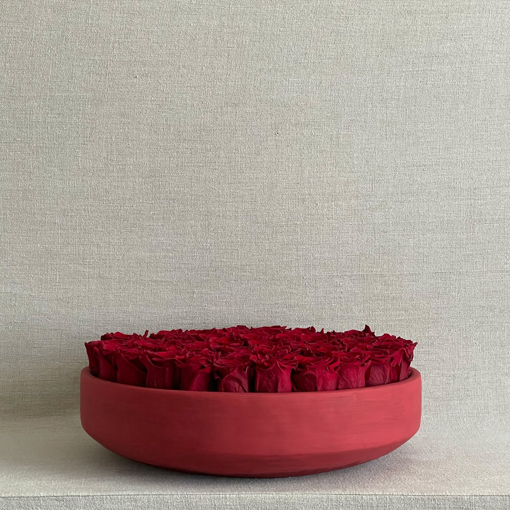 Elegant preserved red roses beautifully arranged in a sleek red bowl for a minimalist centerpiece