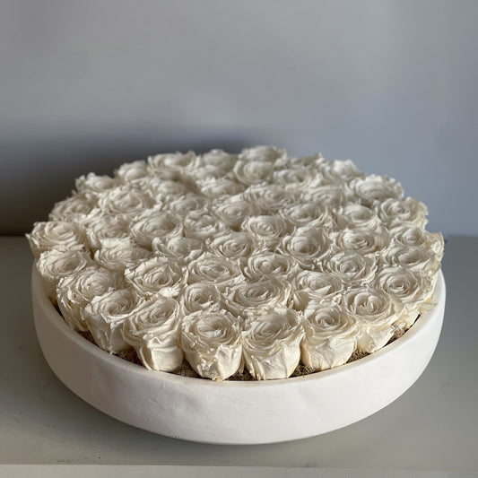 A full top-down view of the white rose serene, showcasing pristine white preserved roses arranged in a smooth, round white bowl, with a refined, minimalistic style.