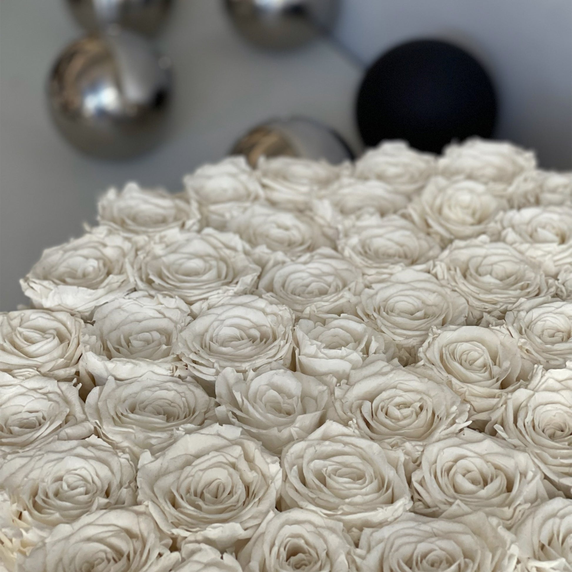 A detailed close-up of preserved white roses in the serene bowl, highlighting the elegance and soft petals against a clean backdrop.