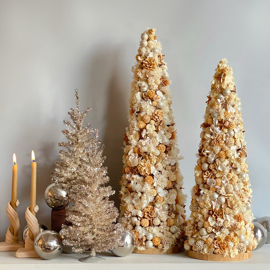 Two preserved floral cones styled together with holiday decor, emphasizing the warm, natural tones.